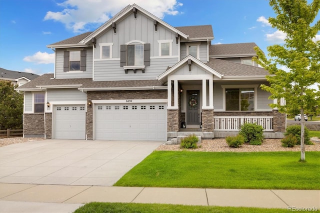 6692 S Robertsdale Way, Aurora, CO 80016 - craftsman house featuring board and batten siding, a porch, a front lawn, an attached garage, and driveway