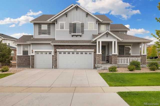 6692 S Robertsdale Way, Aurora, CO 80016 - craftsman house featuring board and batten siding, a garage, stone siding, and a porch
