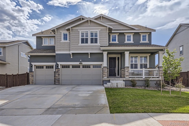 craftsman-style house featuring covered porch, a front lawn, and a garage