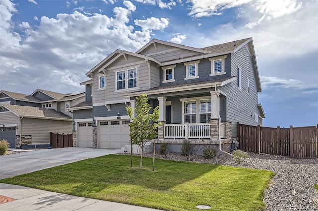 craftsman inspired home with a porch, a front lawn, and a garage