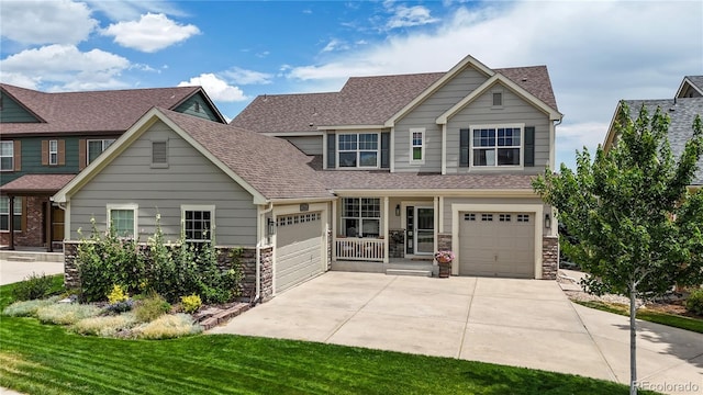 craftsman-style house featuring a garage, covered porch, and a front yard