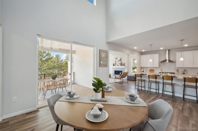 dining space featuring dark hardwood / wood-style flooring and a high ceiling