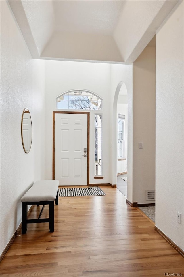 foyer entrance featuring vaulted ceiling and light wood-type flooring