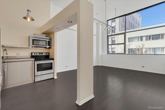 kitchen with appliances with stainless steel finishes, dark wood-style flooring, and baseboards