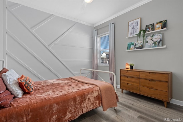 bedroom with ceiling fan, crown molding, baseboards, and wood finished floors