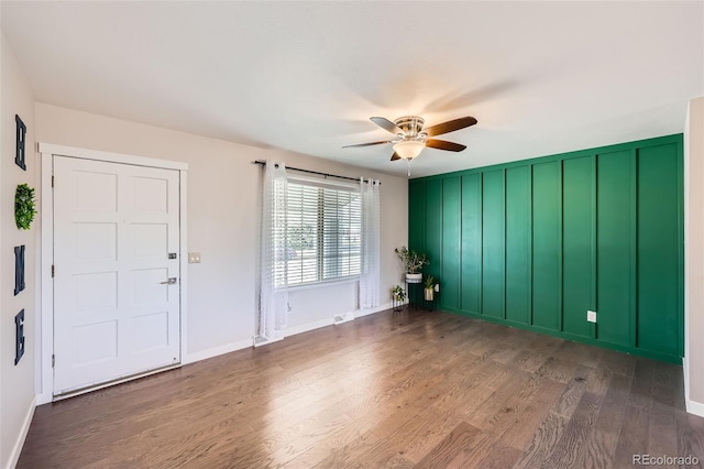 empty room featuring baseboards, wood finished floors, and ceiling fan