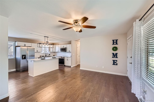 kitchen featuring a kitchen island, white cabinetry, appliances with stainless steel finishes, ceiling fan, and dark wood-style flooring