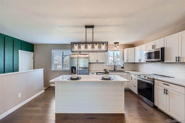 kitchen featuring dark wood-type flooring, backsplash, and appliances with stainless steel finishes