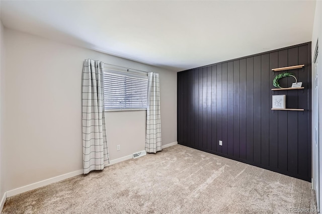 empty room with visible vents, carpet floors, and baseboards