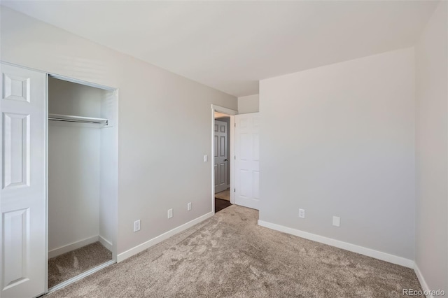 unfurnished bedroom with baseboards, carpet floors, and a closet