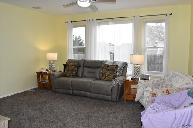 living room featuring a healthy amount of sunlight, ceiling fan, and dark colored carpet