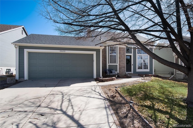 single story home featuring brick siding, roof with shingles, concrete driveway, and an attached garage