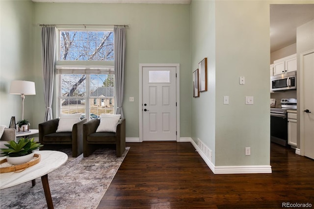 entryway featuring dark wood finished floors, baseboards, and visible vents