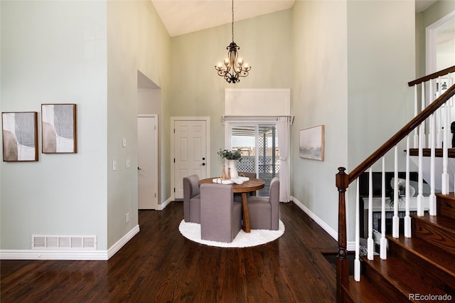 foyer entrance with visible vents, baseboards, stairs, wood finished floors, and high vaulted ceiling