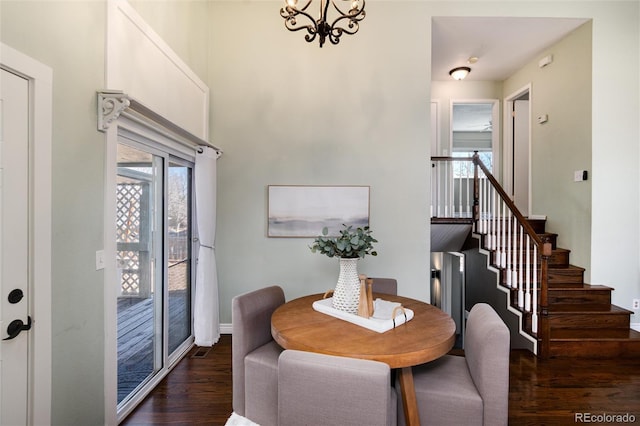 dining area featuring stairway, an inviting chandelier, and wood finished floors