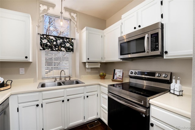 kitchen with a sink, stainless steel appliances, white cabinets, and light countertops