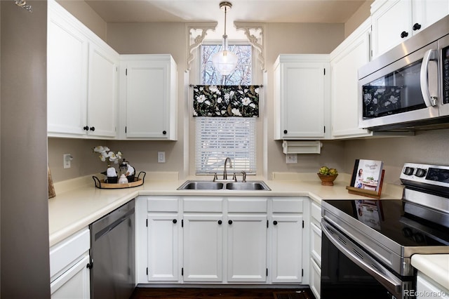 kitchen with a sink, appliances with stainless steel finishes, and white cabinetry