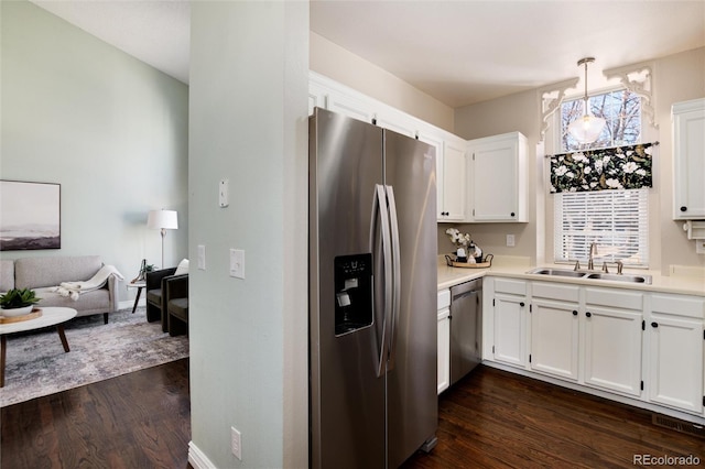 kitchen featuring dark wood-style flooring, a sink, stainless steel appliances, light countertops, and white cabinets