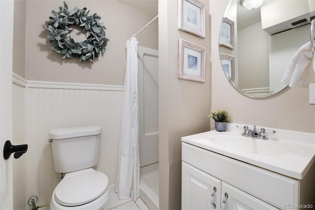 bathroom featuring a wainscoted wall, toilet, vanity, and a shower with curtain