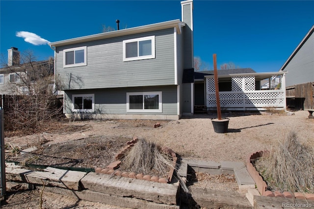 back of house with fence and a chimney