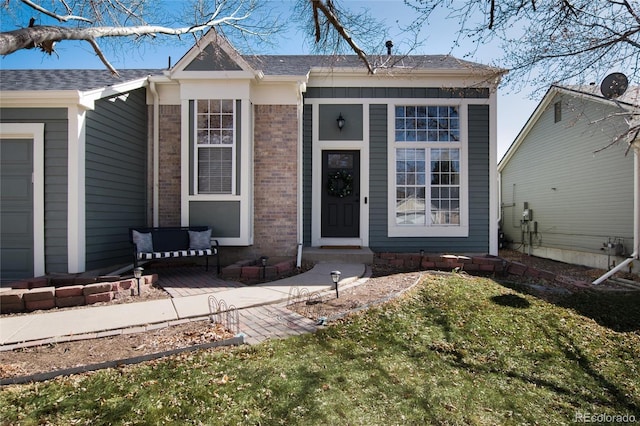 exterior space with brick siding and a front lawn