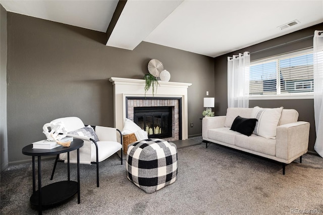 carpeted living area with visible vents, baseboards, and a fireplace