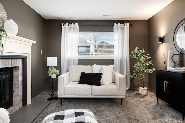 carpeted living room with visible vents, a brick fireplace, and baseboards