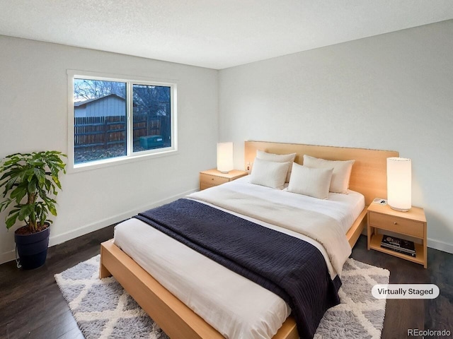 bedroom with dark hardwood / wood-style floors and a textured ceiling