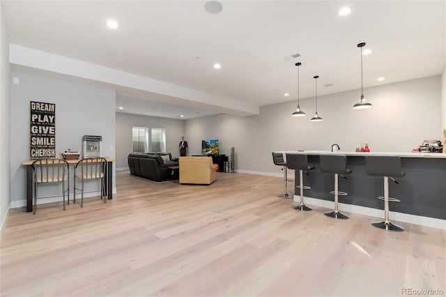 interior space with recessed lighting, light wood-style flooring, and a kitchen bar