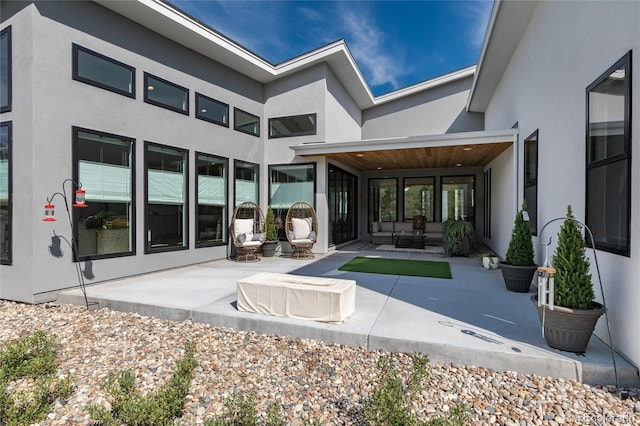 back of property with an outdoor hangout area and a patio area