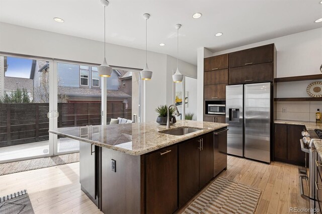 kitchen with dark brown cabinets, a sink, stainless steel appliances, and open shelves