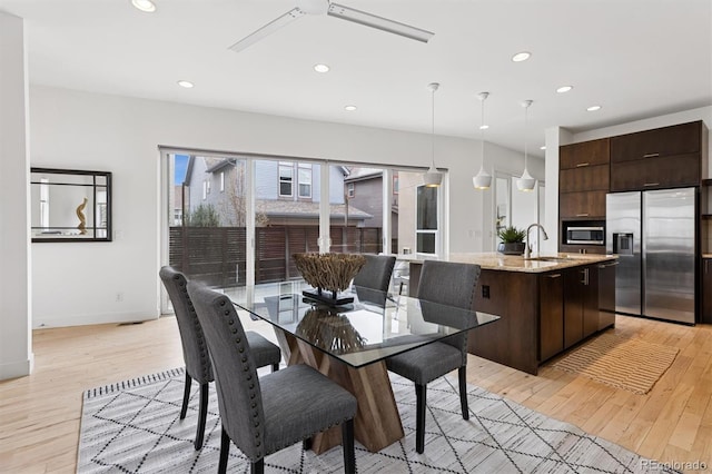 dining space with baseboards, light wood-style floors, and recessed lighting