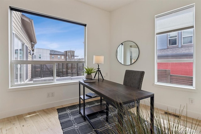 home office featuring baseboards, visible vents, and wood finished floors