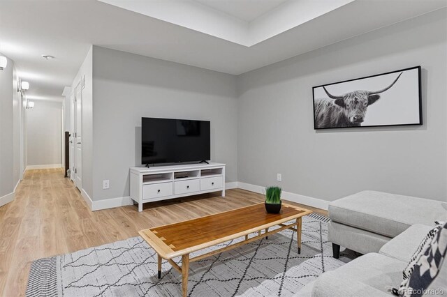 living area with baseboards and light wood finished floors