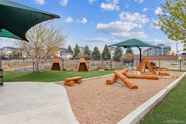 view of playground featuring a lawn and fence