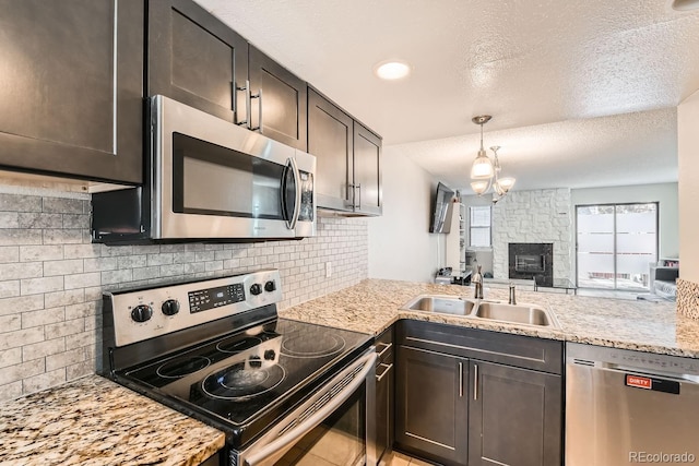 kitchen with backsplash, a textured ceiling, stainless steel appliances, dark brown cabinetry, and sink