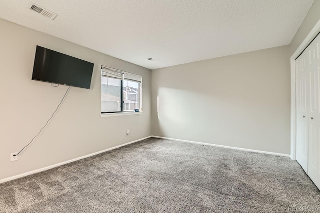 unfurnished bedroom with a closet, carpet, and a textured ceiling