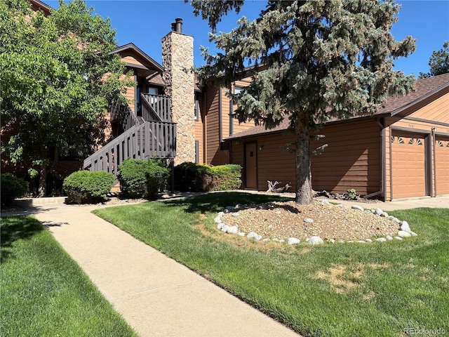 view of front of property with a front lawn, a chimney, and an attached garage