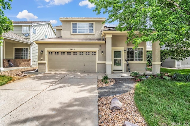 19463 E Hollow Creek Dr, Parker, CO 80134 - view of front of property with stucco siding, concrete driveway, roof mounted solar panels, an attached garage, and a tiled roof