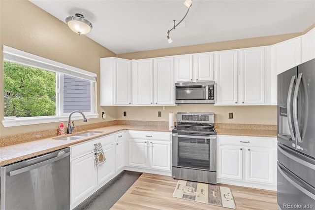 19463 E Hollow Creek Dr, Parker, CO 80134 - kitchen with appliances with stainless steel finishes, light countertops, white cabinets, and light wood-style floors