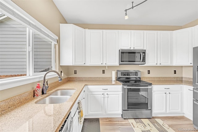 19463 E Hollow Creek Dr, Parker, CO 80134 - kitchen featuring appliances with stainless steel finishes, white cabinets, light wood-style flooring, and light stone countertops
