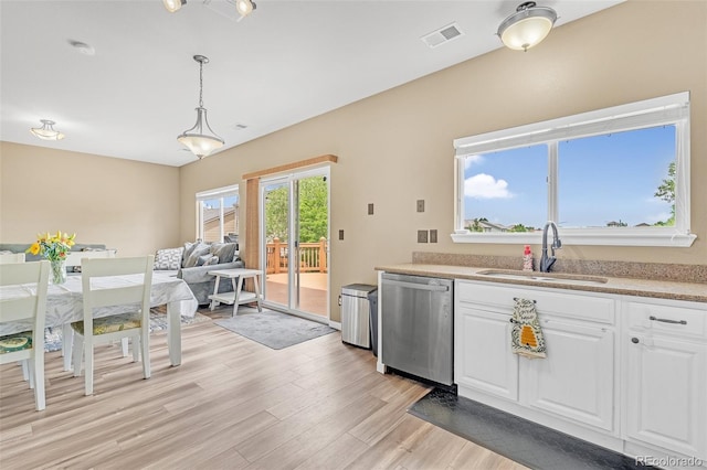 19463 E Hollow Creek Dr, Parker, CO 80134 - kitchen featuring stainless steel dishwasher, white cabinetry, light wood-style flooring, and light countertops