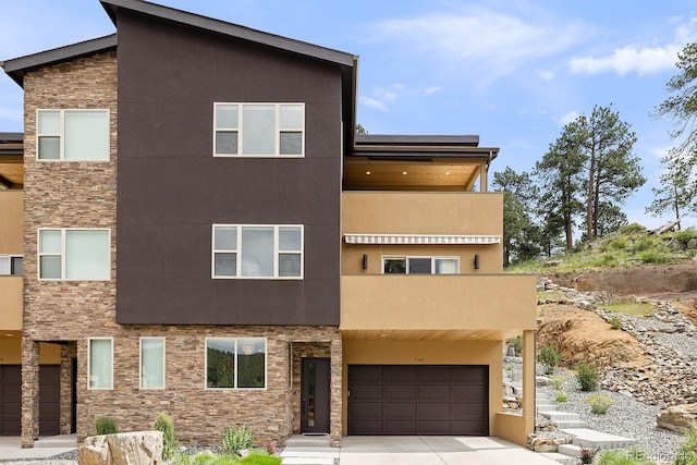 766 Dreamcatcher Ln, Evergreen, CO 80439 - contemporary home featuring stone siding, a garage, stucco siding, and concrete driveway