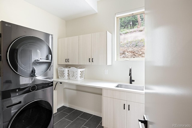 766 Dreamcatcher Ln, Evergreen, CO 80439 - washroom featuring stacked washing machine and dryer, cabinet space, and dark tile patterned floors
