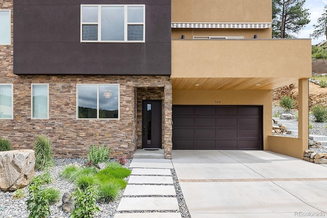 766 Dreamcatcher Ln, Evergreen, CO 80439 - view of front of home with stucco siding, driveway, a garage, and stone siding