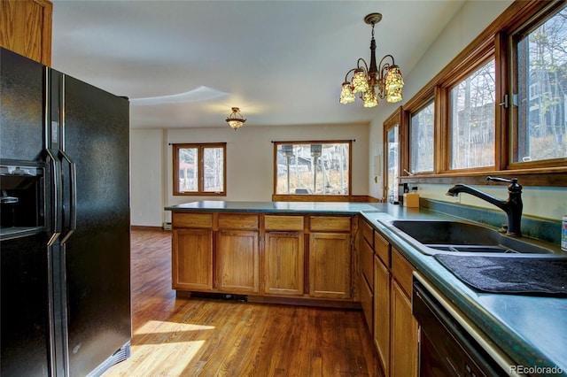 kitchen with black fridge, a wealth of natural light, sink, and light wood-type flooring