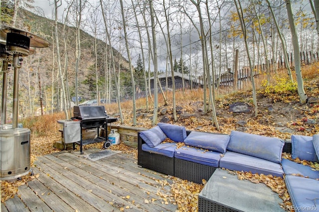 wooden deck with an outdoor hangout area and grilling area