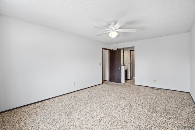 spare room featuring baseboards, light colored carpet, a textured ceiling, and a ceiling fan