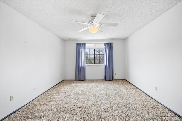 spare room with ceiling fan, light carpet, and a textured ceiling
