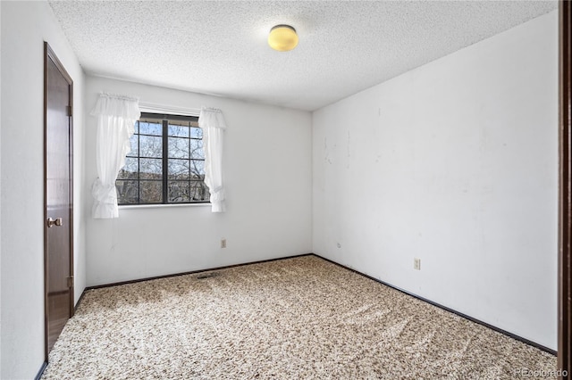 unfurnished bedroom featuring a textured ceiling, baseboards, and carpet